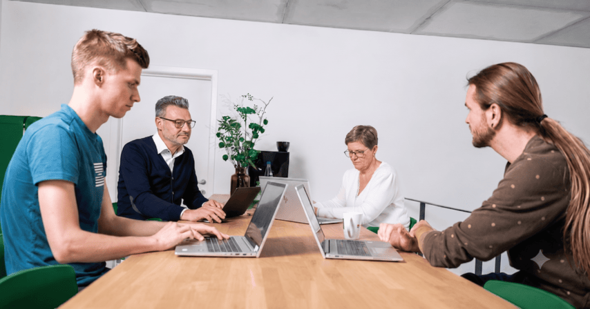 SELAS-team werkt samen aan tafel met laptops